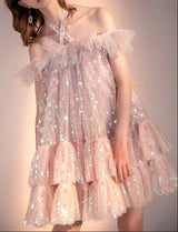 Pink sparkly dress worn by a person on a plain background